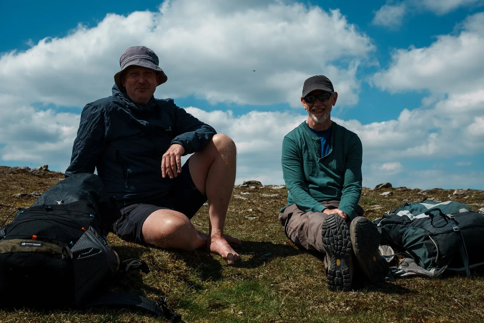 Two men resting on the grass after the descent