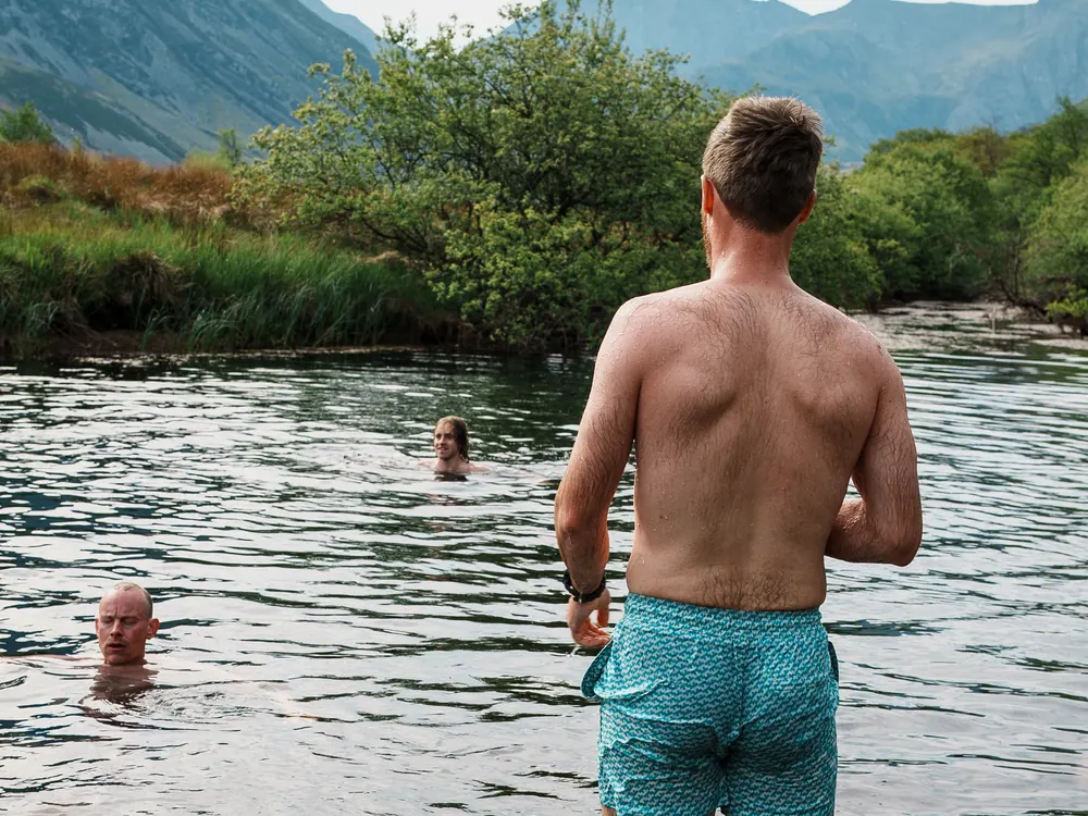 A man wading into the lake for a wild swim